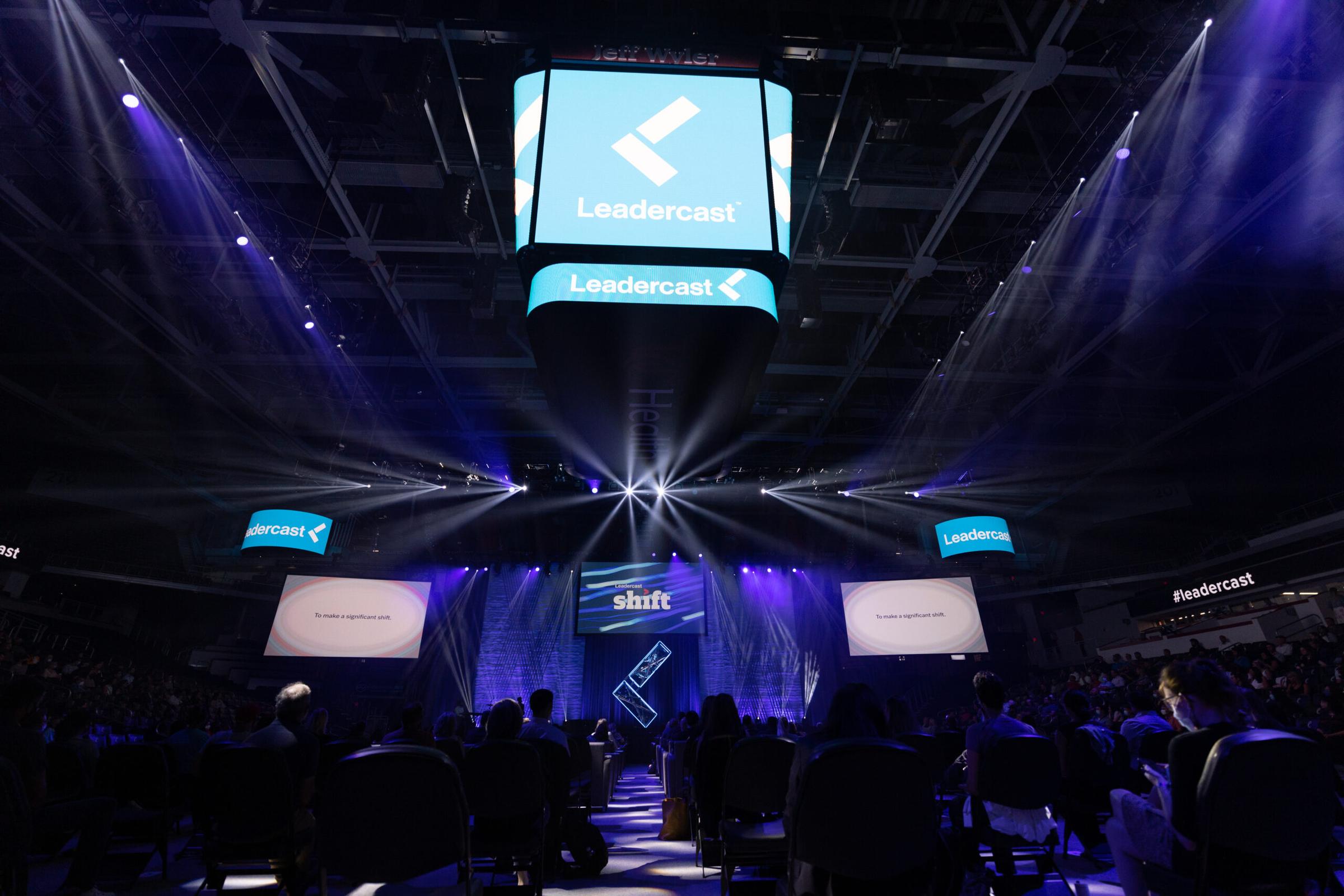 Audience facing the illuminated Leadercast Shift stage